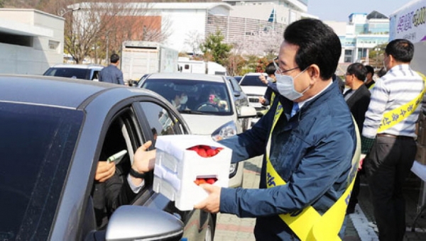 김영록 지사가 드라이브 스루 매장을 찾은 시민들에게 딸기를 판매하고 있다.